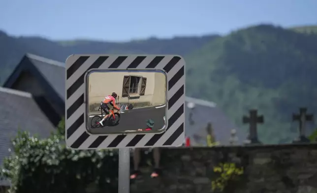 Reflected in a mirror, Britain's Geraint Thomas climbs during the thirteenth stage of the Tour de France cycling race, an individual time-trial over 10.5 kilometers (6.5 miles) in the Pyrenees mountains with start in Loudenvielle and finish in Peyragudes, France, Friday, July 18, 2025. (AP Photo/Mosa'ab Elshamy)