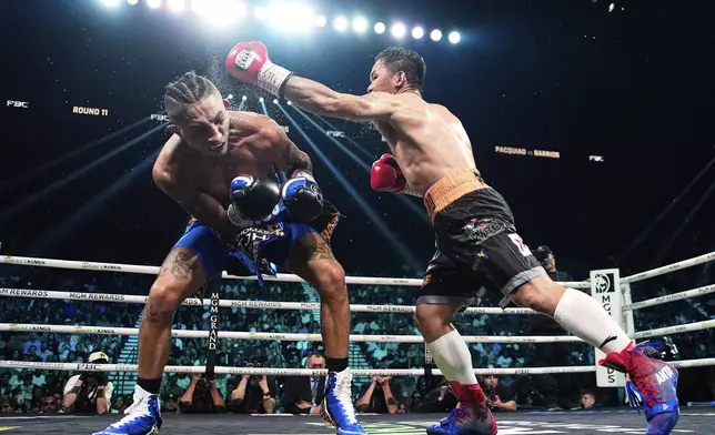 Mario Barrios, left, fights Manny Pacquiao in a welterweight title boxing match Saturday, July 19, 2025, in Las Vegas. (AP Photo/John Locher)