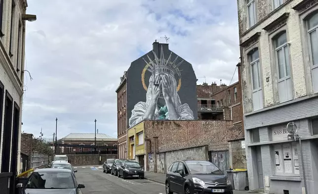 A mural by Dutch artist Judith de Leeuw shows the Statue of Liberty covering her eyes with her hands, in Roubaix, northern France, Monday, July 14, 2025. (AP Photo/Sylvain Plazy)