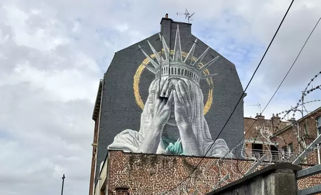 A mural by Dutch artist Judith de Leeuw shows the Statue of Liberty covering her eyes with her hands, in Roubaix, northern France, Monday, July 14, 2025. (AP Photo/Sylvain Plazy)
