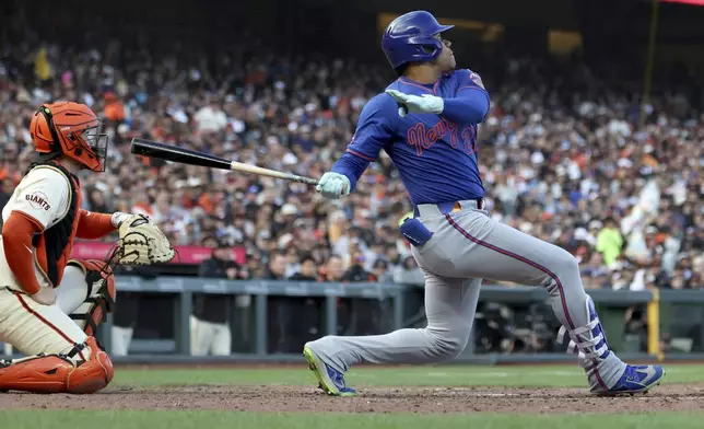 New York Mets' Juan Soto, right, hits a home run in front of San Francisco Giants catcher Patrick Bailey, left, during the seventh inning of a baseball game in San Francisco, Sunday, July 27, 2025. (AP Photo/Jed Jacobsohn)
