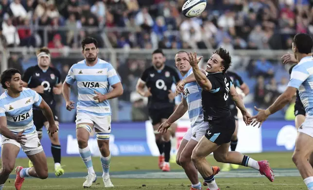 England's Cadan Murley, right, reaches for the ball during a rugby test match against Argentina in San Juan, Argentina, Saturday, July 12, 2025. (AP Photo/Nicolas Aguilera)