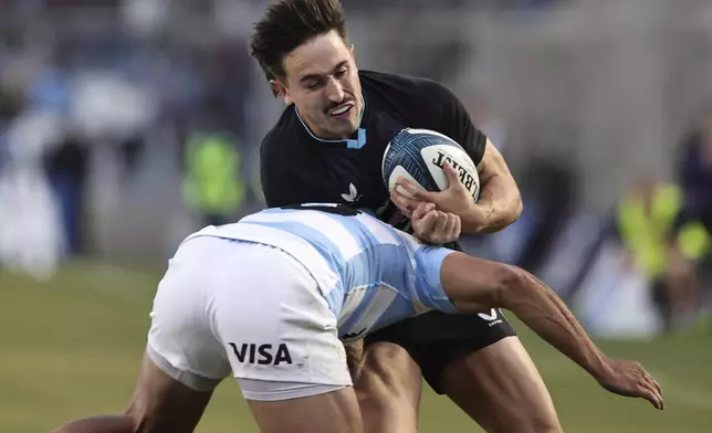 England's Cadan Murley is tackled by Argentina's Santiago Carreras during a rugby test match in San Juan, Argentina, Saturday, July 12, 2025. (AP Photo/Nicolas Aguilera)