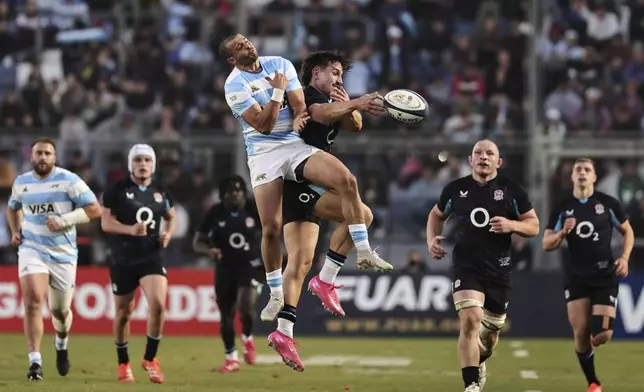 England's Cadan Murley, center right, and Argentina's Nicolas Roger fight for the ball during a rugby test match in San Juan, Argentina, Saturday, July 12, 2025. (AP Photo/Nicolas Aguilera)