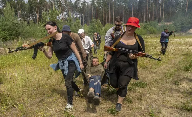 Civilians practice military skills on a training ground in Kharkiv, Ukraine, Saturday, July 12, 2025. (AP Photo/Andrii Marienko)