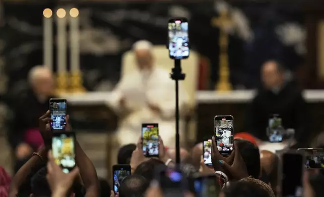 Faithful film with their phones Pope Leo XIV delivering his. Message at the end of a mass celebrated by Cardinal Luis Antonio Tagle in St. Peter's Basilica on the occasion of the Youth Jubilee at the Vatican, Tuesday, July 29, 2025. (AP Photo/Gregorio Borgia)