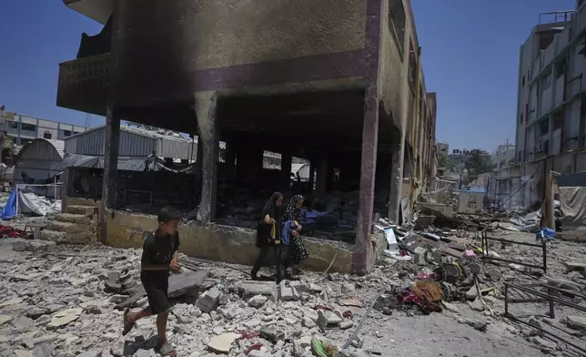 Palestinians survey the destruction at a school used as a shelter after it was struck by an Israeli airstrike in Gaza City, on Thursday, July 3, 2025. (AP Photo/Jehad Alshrafi)