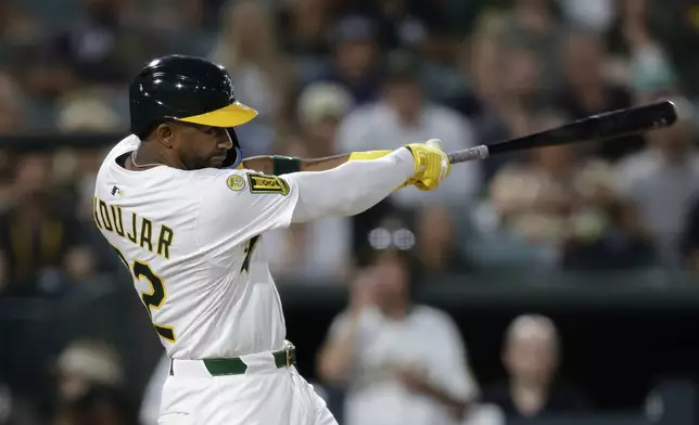 Athletics' Miguel Andujar hits an RBI double during the fifth inning of a baseball game against the Seattle Mariners Tuesday, July 29, 2025, in West Sacramento, Calif. (AP Photo/Sergio Estrada)