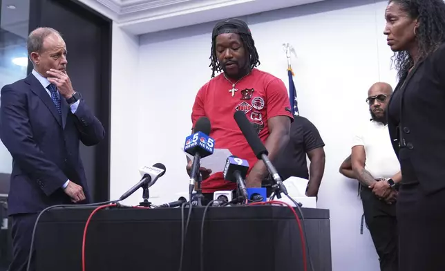 One sexual assault survivor Michael Moss, center, talks to media as Jerome Block, partner, Levy &amp; Konigsberg LLP, left, and attorney Kristen Feden listen to him during a news conference in Chicago, Wednesday, July 16, 2025. (AP Photo/Nam Y. Huh)
