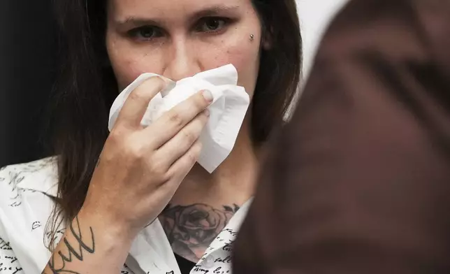 One of sexual assault survivor Kate-Lynn (first name only), wipes his face after talking to media during a news conference in Chicago, Wednesday, July 16, 2025. (AP Photo/Nam Y. Huh)