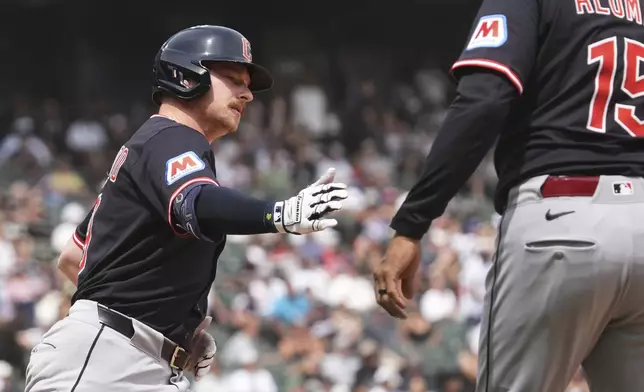 Cleveland Guardians' Kyle Manzardo, left, rounds the bases as he celebrates with first base coach Sandy Alomar Jr. after hitting a three-run home run during the sixth inning of a baseball game against the Chicago White Sox in Chicago, Sunday, July 13, 2025. (AP Photo/Nam Y. Huh)