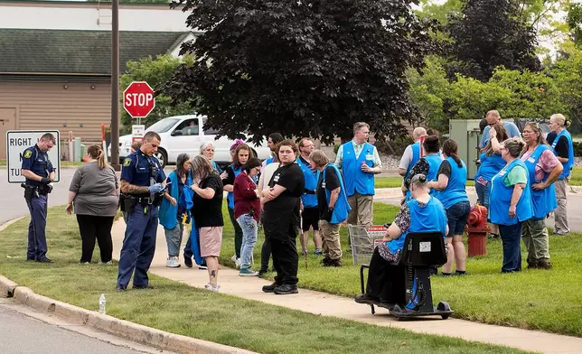 Michigan State Police officers talk to employees near the scene after a stabbing incident at a Walmart in Traverse City, Mich., Saturday July 26, 2025. (Jan-Michael Stump/Traverse City Record-Eagle via AP)