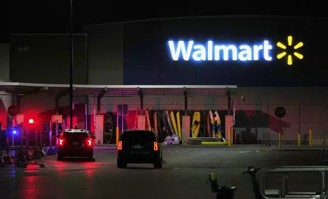 Law enforcement officers are seen stationed outside a Walmart where 11 people were stabbed in a violent attack Saturday, July 26, 2025, in Traverse City, Mich (AP Photo/Ryan Sun)