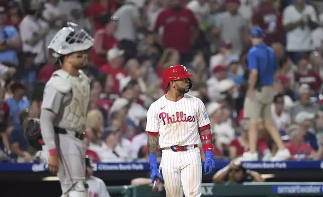 Philadelphia Phillies' Edmundo Sosa, right, and Boston Red Sox catcher Carlos Narváez wait for umpires to make a catcher's interference call with the bases loaded during the 10th inning of a baseball game Monday, July 21, 2025, in Philadelphia. (AP Photo/Matt Slocum)