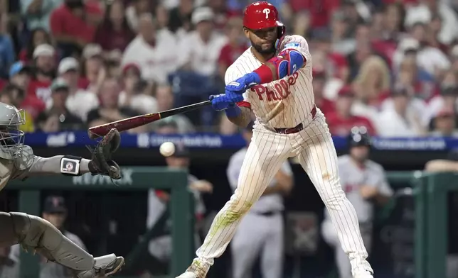 Philadelphia Phillies' Edmundo Sosa, right, hits the glove of Boston Red Sox catcher Carlos Narváez for catcher's interference with the bases loaded in the 10th inning of a baseball game Monday, July 21, 2025, in Philadelphia. (AP Photo/Matt Slocum)
