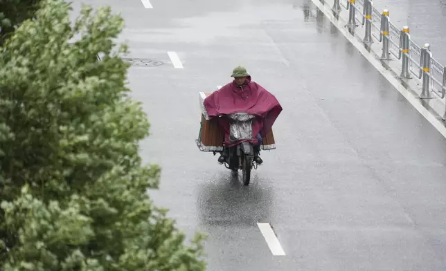 A motorcyclist drives in the rain caused by tropical storm Wipha in Hanoi, Vietnam on Tuesday, July 22, 2025. (AP Photo/Hau Dinh)