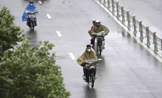 Motorcyclists drive in the rain caused by tropical storm Wipha in Hanoi, Vietnam on Tuesday, July 22, 2025. (AP Photo/Hau Dinh)