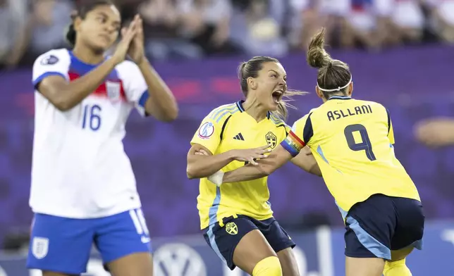 Sweden's Kosovare Asllani, right, and Johanna Rytting Kaneryd, celebrate beside England's Jessica Carter, left, after Asllani scored the opening goal during the Women's Euro 2025 quarterfinals soccer match between Sweden and England at Stadion Letzigrund in Zurich, Switzerland, Thursday, July 17, 2025. (Ennio Leanza/Keystone via AP)