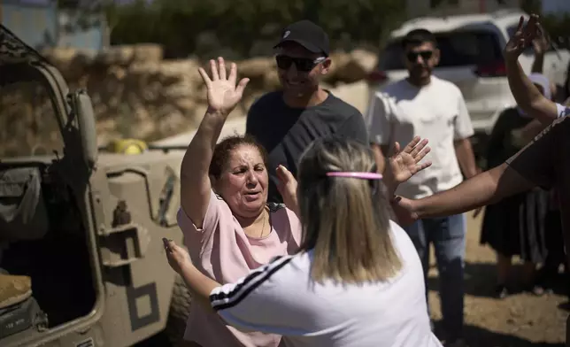 A Syrian Druze woman bids farewell to Druze relatives and friends from Israel before crossing back into Syria at the Israeli-Syrian border, in the Israeli-controlled Golan Heights town of Majdal Shams, Thursday, July 17, 2025. (AP Photo/Leo Correa)