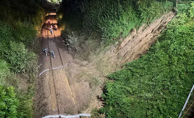 Emergency services work on the tracks by a landslide after a regional passenger train derailed near Riedlingen, Germany, Sunday, July 27, 2025. (Nico Pointner/dpa via AP)