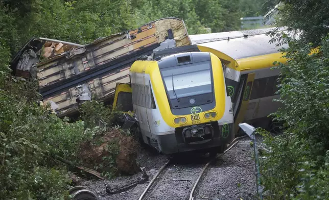 Wagons of a derailed regional passenger train lie on a railroad line near Riedlingen, Germany, Monday, July 28, 2025. (Thomas Warnack/dpa via AP)