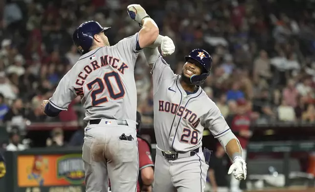 Houston Astros' Brice Matthews (28) celebrates his two-run home run against the Arizona Diamondbacks with Astros' Chas McCormick (20) during the seventh inning of a baseball game Monday, July 21, 2025, in Phoenix. (AP Photo/Ross D. Franklin)