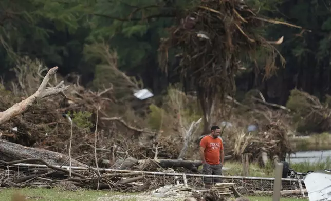 A man surveys debris and flood damage along the Guadalupe River, Sunday, July 13, 2025, in Kerrville, Texas. (AP Photo/Eric Gay)