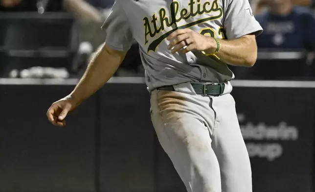 Athletics' Colby Thomas scores on a sacrifice fly by Austin Wynns, not pictured, during the 10th inning of a baseball game against the Tampa Bay Rays, Tuesday, July 1, 2025, in Tampa, Fla. (AP Photo/Jason Behnken)