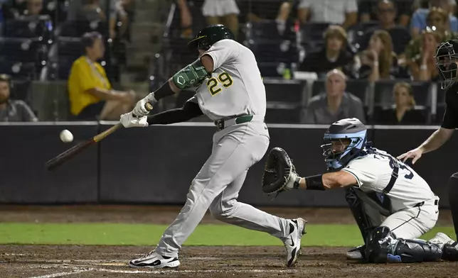 Athletics' Austin Wynns (29) hits a sacrifice fly during the 10th inning of a baseball game against the Tampa Bay Rays, Tuesday, July 1, 2025, in Tampa, Fla. (AP Photo/Jason Behnken)