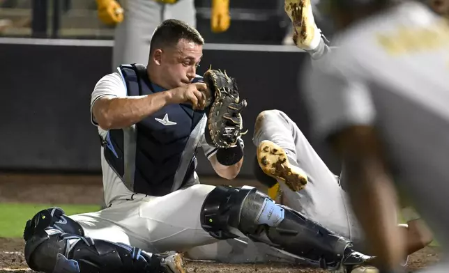 Tampa Bay Rays catcher Matt Thaiss tags out Athletics' Max Schuemann at home plate during the tenth inning of a baseball game Tuesday, July 1, 2025, in Tampa, Fla. (AP Photo/Jason Behnken)