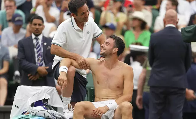 Pedro Martinez of Spain receives treatment during a medical timeout as he plays Jannik Sinner of Italy during a third round men's singles match at the Wimbledon Tennis Championships in London, Saturday, July 5, 2025. (AP Photo/Kirsty Wigglesworth)