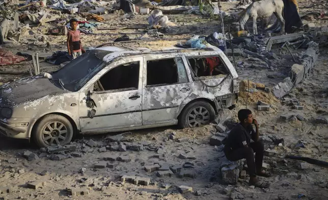 Palestinians inspect the site struck by an Israeli bombardment in Muwasi, Khan Younis, Gaza Strip, Monday, July 28, 2025. (AP Photo/Mariam Dagga)
