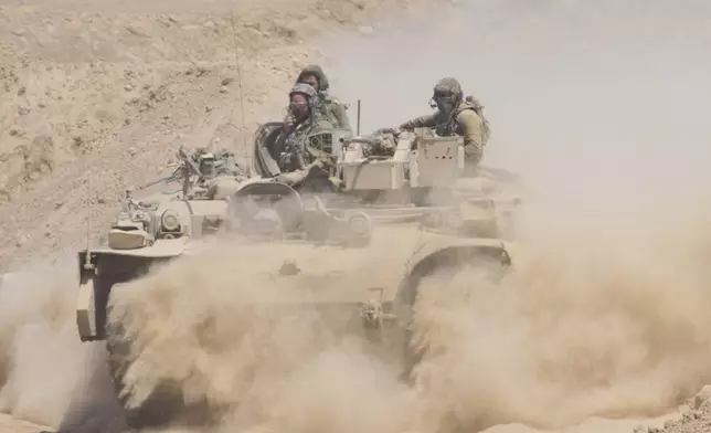 Israeli soldiers drive on their armored personnel carrier back from inside the northern Gaza Strip into southern Israel, Tuesday, July 29, 2025. (AP Photo/Ariel Schalit)