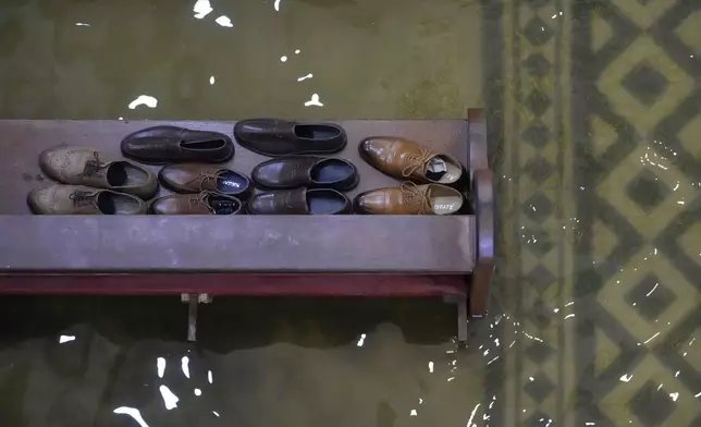 Guests leave their shoes on a pew during a wedding at the flooded Barasoain church in Malolos, Bulacan province, Philippines on Tuesday, July 22, 2025. (AP Photo/Aaron Favila)