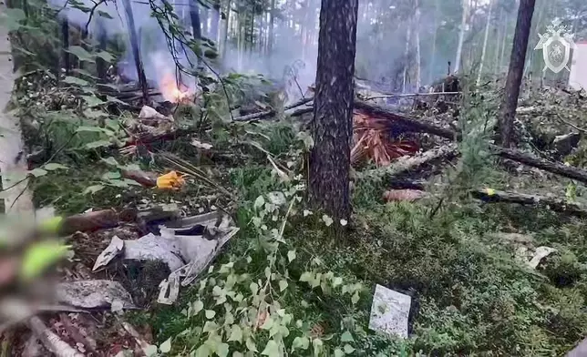 In this photo taken from video released by Russian Investigative Committee on Thursday, July 24, 2025, a view of the place of the crashed Russian An-24 passenger plane of the Siberia-based Angara Airlines while carrying 49 passengers in 15 kilometers (9 miles) south of Tynda, Far Eastern Amur region of Russia. (Russian Investigative Committee via AP)