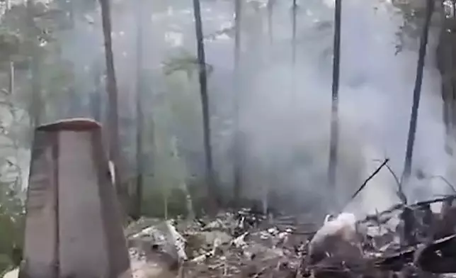 In this photo taken from video released by Russian Far Eastern Transport Prosecutor's Office on Thursday, July 24, 2025, a view of the place of the crashed Russian An-24 passenger plane of the Siberia-based Angara Airlines while carrying 49 passengers in 15 kilometers (9 miles) south of Tynda, Far Eastern Amur region of Russia. (Russian Far Eastern Transport Prosecutor's Office via AP)