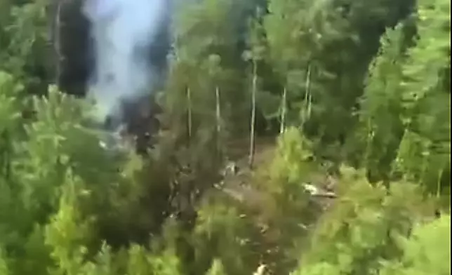 In this photo taken from video released by Russia Emergency Situations Ministry press service on Thursday, July 24, 2025, smoke rises from the crash site of a Russian An-24 passenger plane of the Siberia-based Angara Airlines about 15 kilometers (9 miles) south of Tynda, Far Eastern Amur region of Russia. (Russia Emergency Situations Ministry press service via AP)