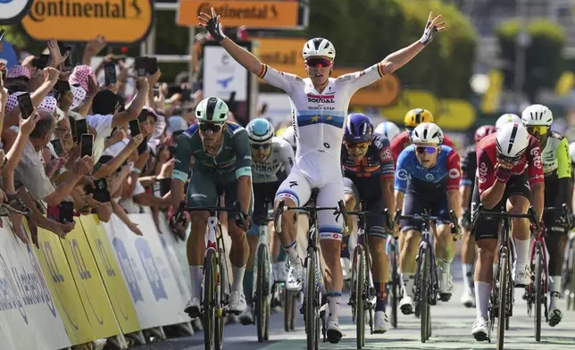 Stage winner Belgium's Tim Merlier crosses the finish line ahead of second place Italy's Jonathan Milan, wearing the best sprinter's green jersey, and third place Belgium's Arnaud de Lie, right, during the ninth stage of the Tour de France cycling race over 174.1 kilometers (108 miles) with start in Chinon and finish in Chateauroux, France, Sunday, July 13, 2025. (AP Photo/Thibault Camus)