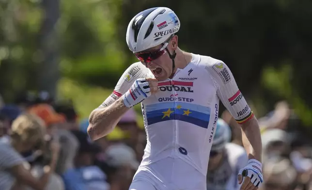 Stage winner Belgium's Tim Merlier celebrates as he crosses the finish line of the ninth stage of the Tour de France cycling race over 174.1 kilometers (108 miles) with start in Chinon and finish in Chateauroux, France, Sunday, July 13, 2025. (AP Photo/Thibault Camus)