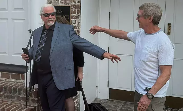 Bhagavan “Doc” Antle from the Netflix Tiger King documentary, center, reaches out to a supporter after he was sentenced to a year and a day in prison on federal animal trafficking and money laundering charges on Tuesday, July 8, 2025 in Charleston, S.C. (AP Photo/Jeffrey Collins)