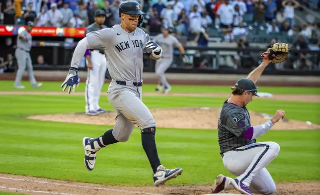 New York Yankees' Aaron Judge, left, is out at first base during the ninth inning of a baseball game against the New York Mets, Saturday, July 5, 2025, in New York. (AP Photo/Angelina Katsanis)