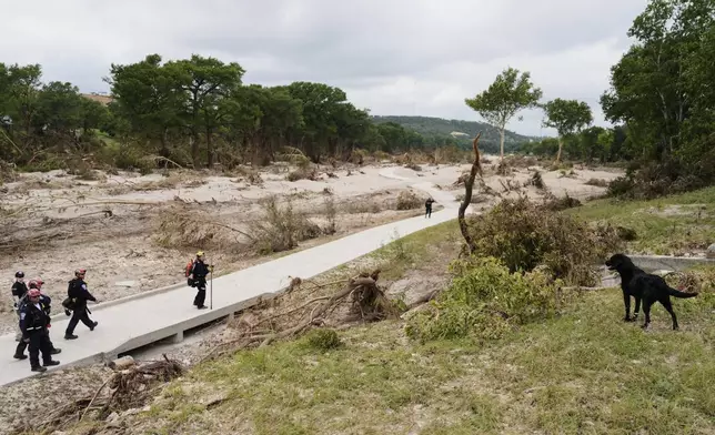 Members of Orange County Task Force One search for missing flood victims in Kerrville, Texas, Friday, July 11, 2025. (AP Photo/Ashley Landis)