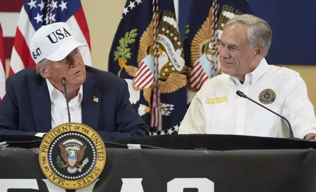 President Donald Trump, left, speaks as Texas Gov. Greg Abbott listens during a roundtable discussion with first responders and local officials at Hill Country Youth Event Center in Kerrville, Texas, during a tour to observe flood damage, Friday, July 11, 2025. (AP Photo/Jacquelyn Martin)