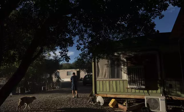 Virgilio Galarza Rodriguez works outside his mobile home in Oasis, Calif., Wednesday, Oct. 30, 2024. (AP Photo/Jae C. Hong)