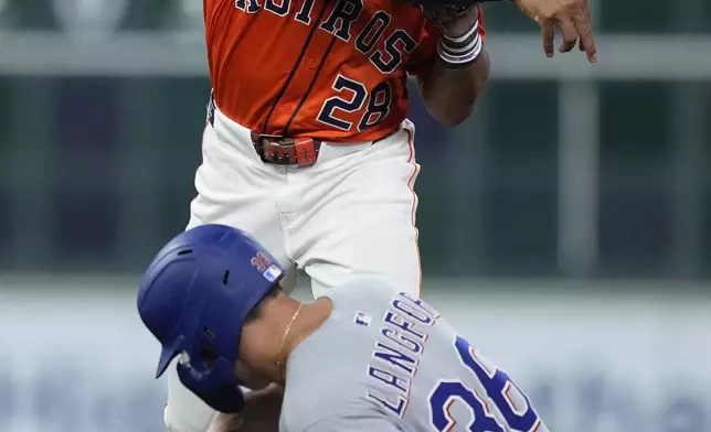 Houston Astros second baseman Brice Matthews (28) throws to first base for a double play after forcing out Texas Rangers' Wyatt Langford at second base during the fifth inning of a baseball game Friday, July 11, 2025, in Houston. (AP Photo/Kevin M. Cox)