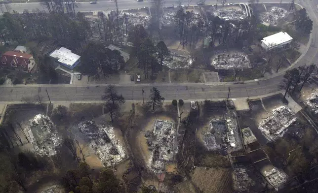 FILE - Houses that have burned to the ground by the Cerro Grande fire sit along a street in north Los Alamos, N.M., May 12, 2000. (AP Photo/Jake Schoellkopf, File)
