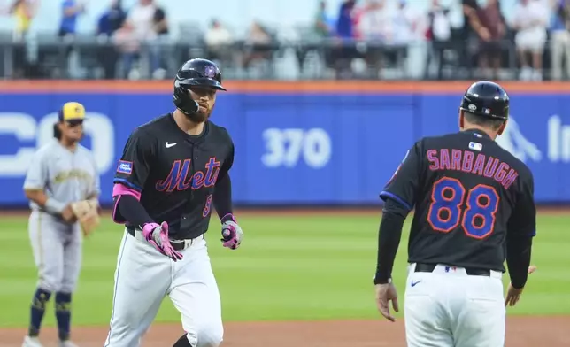 New York Mets' Brandon Nimmo (9) celebrates with third base coach Mike Sarbaugh (88) as he runs the bases after hitting a grand slam during the second inning in the second baseball game of a doubleheader Wednesday, July 2, 2025, in New York. (AP Photo/Frank Franklin II)