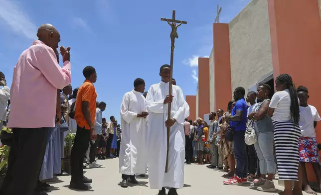 A cross-bearer leads a liturgical procession at the end of a Mass marking the Feast of Our Lady of Mount Carmel at the namesake church in the Pétion-Ville neighborhood of Port-au-Prince, Haiti, on Wednesday, July 16, 2025. (AP Photo/Odelyn Joseph)