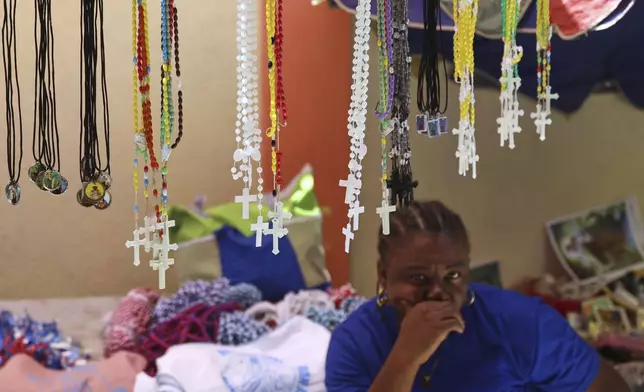 Rosaries for sale hang from a vendor's stand at the entrance of the Mount Carmel Church during a Mass marking the feast day of Our Lady of Mount Carmel, in the Petion-ville neighborhood of Port-au-Prince, Haiti, Wednesday, July 16, 2025.(AP Photo/Odelyn Joseph)