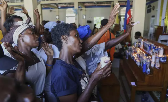 Pilgrims pray during a Mass celebrating the Feast of Our Lady of Mount Carmel at the namesake church in the Pétion-Ville neighborhood of Port-au-Prince, Haiti, on Wednesday, July 16, 2025. (AP Photo/Odelyn Joseph)